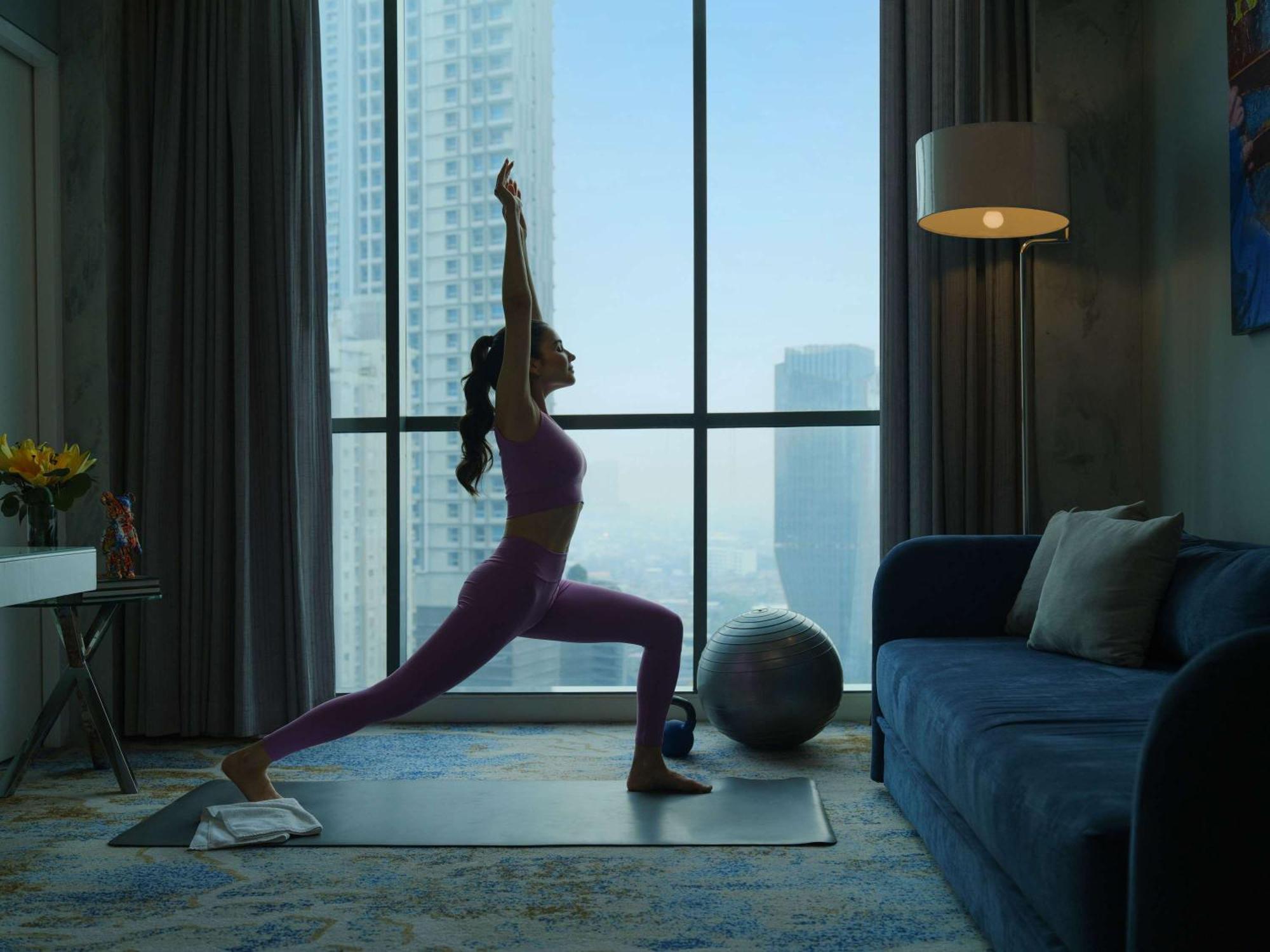 Pullman Jakarta Central Park Екстер'єр фото A woman practicing yoga at home